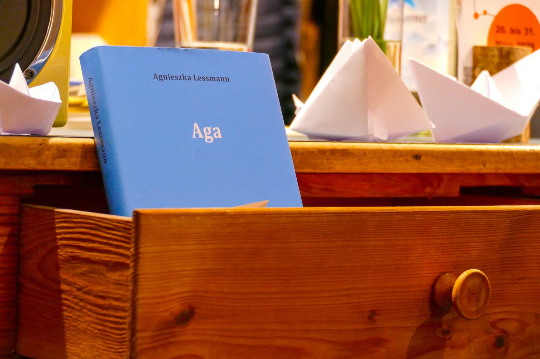 Tisch mit Buch und Papierschiffchen